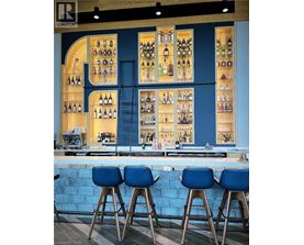 A bar with blue stools and a blue wall.