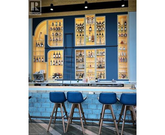 A bar with blue stools and a blue wall.