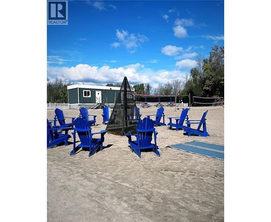 A beach scene with blue chairs and a volleyball net.