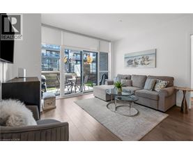 A living room with a grey couch, a glass table, and a television.