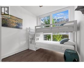 A bedroom with a bunk bed and a painting on the wall.