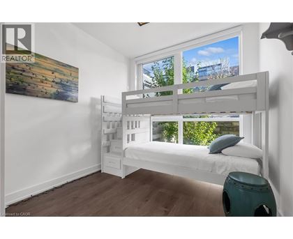 A bedroom with a bunk bed and a painting on the wall.