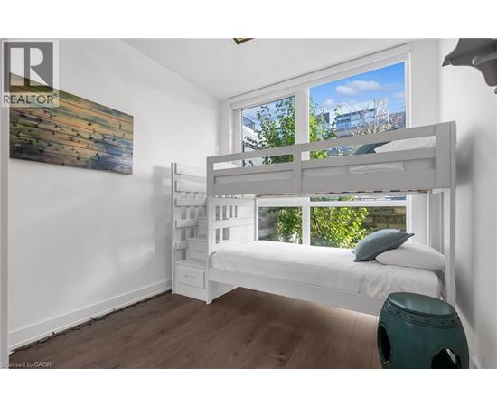 A bedroom with a bunk bed and a painting on the wall.