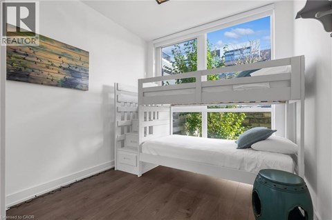 A bedroom with a bunk bed and a painting on the wall.