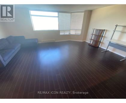 A room with wooden flooring and a couch.