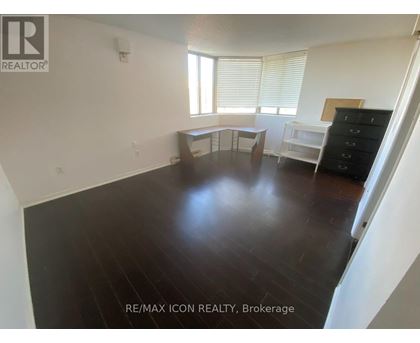 A room with a wooden floor and white walls.
