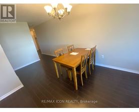 A dining room with a wooden table and chairs.