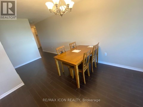 A dining room with a wooden table and chairs.