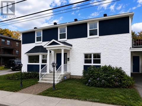A white house with a black roof and a blue trim.