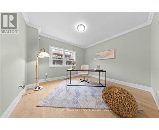 A living room with a leopard print bean bag chair and a blue rug.