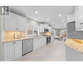 A modern kitchen with white cabinets and a marble countertop.