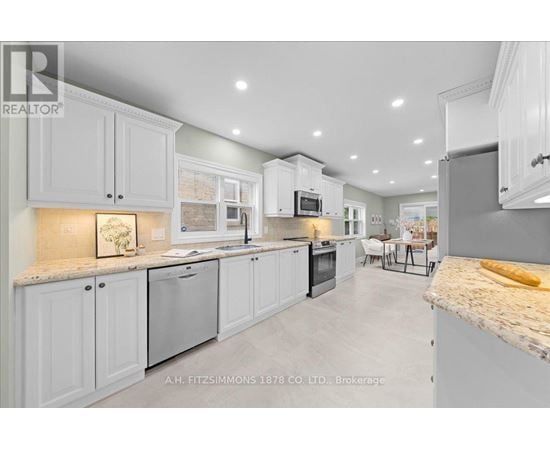 A modern kitchen with white cabinets and a marble countertop.