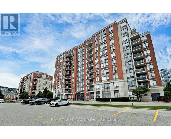 A large apartment building with a parking lot in front of it.