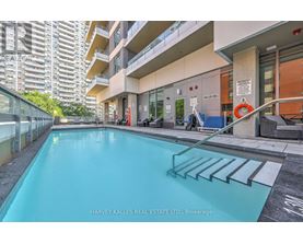 A swimming pool in a residential area with a glass railing.