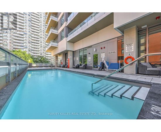 A swimming pool in a residential area with a glass railing.