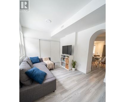 A living room with a grey couch and a television.