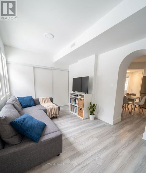 A living room with a grey couch and a television.