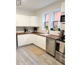 A kitchen with white cabinets and stainless steel appliances.