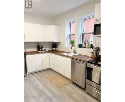A kitchen with white cabinets and stainless steel appliances.