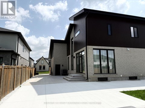 A modern house with a black exterior and a wooden fence in front.