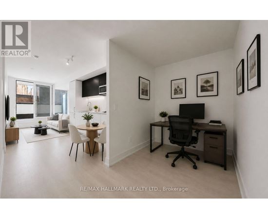 A well-lit, spacious room with a desk, chairs, and a dining area.