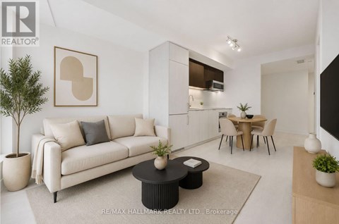 A living room with a white couch, a coffee table, and a dining table with chairs.