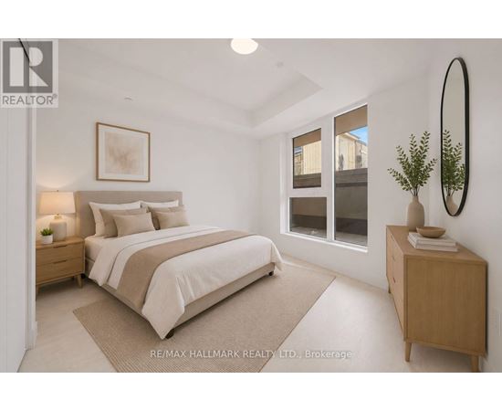 A bedroom with a large bed, a nightstand, and a plant on the side table.