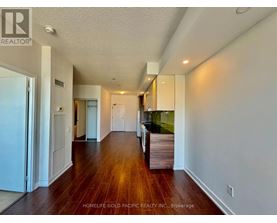 A long hallway with wood floors and white walls.