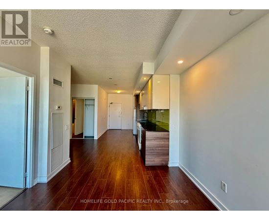 A long hallway with wood floors and white walls.