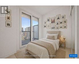 A bedroom with a large bed and pictures on the wall.