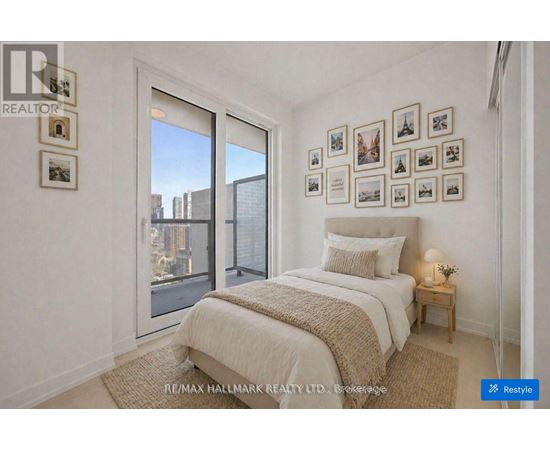 A bedroom with a large bed and pictures on the wall.