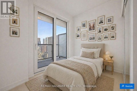 A bedroom with a large bed and pictures on the wall.