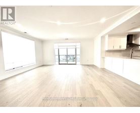 A spacious, empty room with wooden floors and white walls.