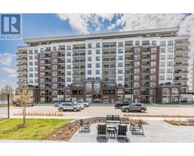 A large apartment complex with a parking lot in front.