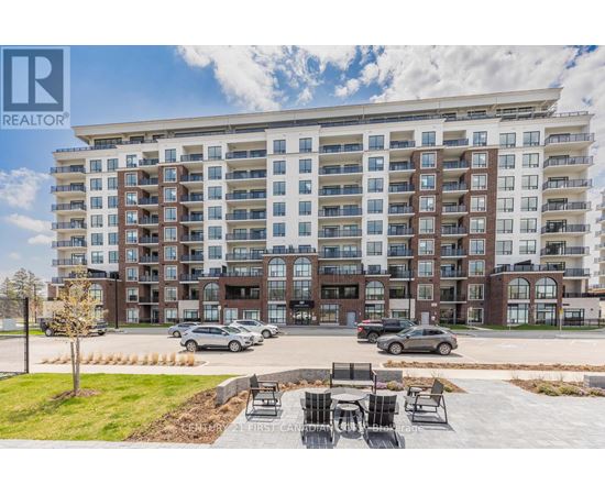 A large apartment complex with a parking lot in front.