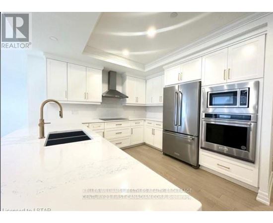 A modern kitchen with stainless steel appliances and white cabinetry.