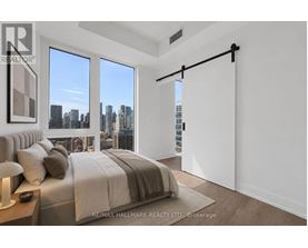 A bedroom with a large bed and a view of the city.