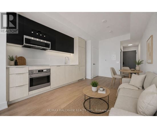 A modern kitchen with a black range hood above the stove and a wooden coffee table in the center of the room.
