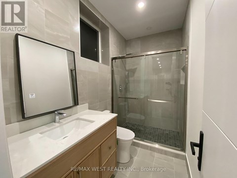 A bathroom with a sink, mirror, and shower.