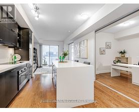 A modern kitchen with dark wood cabinets and stainless steel appliances.