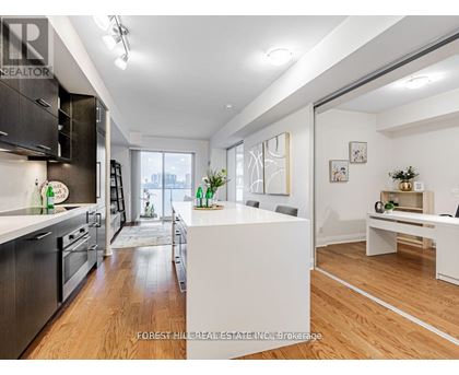 A modern kitchen with dark wood cabinets and stainless steel appliances.