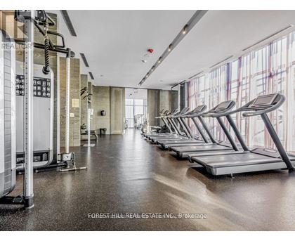 A gym with treadmills and a row of exercise machines.