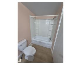 A white toilet and sink in a small bathroom.