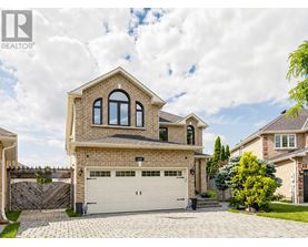 A large house with a garage is surrounded by a fence and has a driveway.