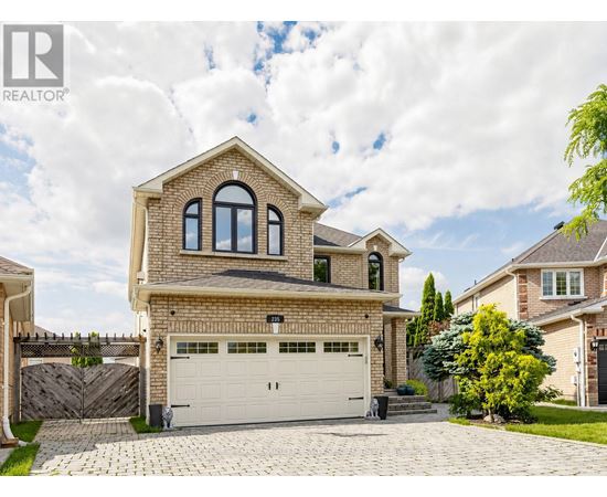A large house with a garage is surrounded by a fence and has a driveway.