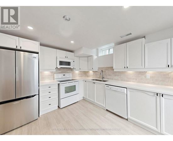 A modern kitchen with white cabinets and stainless steel appliances.