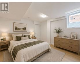 A bedroom with a large bed, nightstands, and a framed picture on the wall.