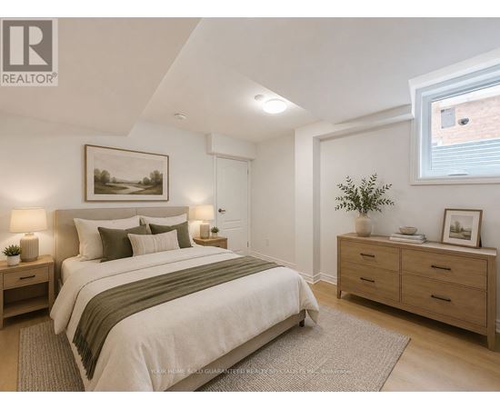 A bedroom with a large bed, nightstands, and a framed picture on the wall.