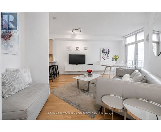 A living room with a grey couch, a coffee table, and a flat screen TV.