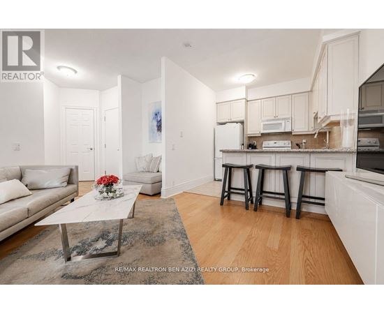 A well-lit, modern kitchen with white cabinets and a breakfast bar.